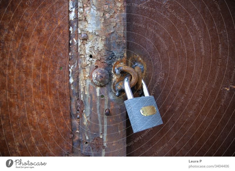 Nahaufnahme eines neuen Eisenschlosses an einem alten, rostigen Tor abschließen bügeln Gate Kontrast Natur metallisch Grunge Schloss Metall Konzept dreckig