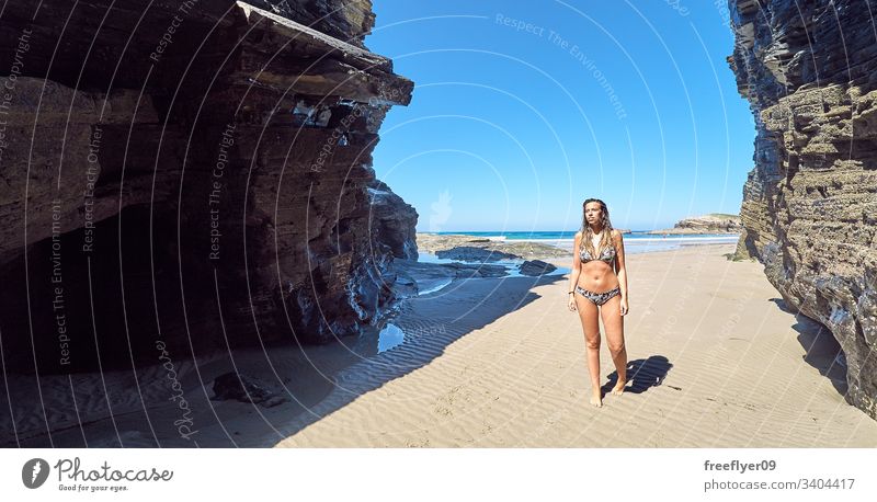 Junge Frau beim Spaziergang an einem Strand mit Klippen in Galicien, Spanien Tourismus wandern Galicia Ribadeo Castros Illas Felsen atlantisch Bucht touristisch