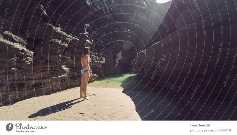 Junge Frau beim Spaziergang an einem Strand mit Klippen in Galicien, Spanien Tourismus wandern Galicia Ribadeo Castros Illas Felsen atlantisch Bucht touristisch