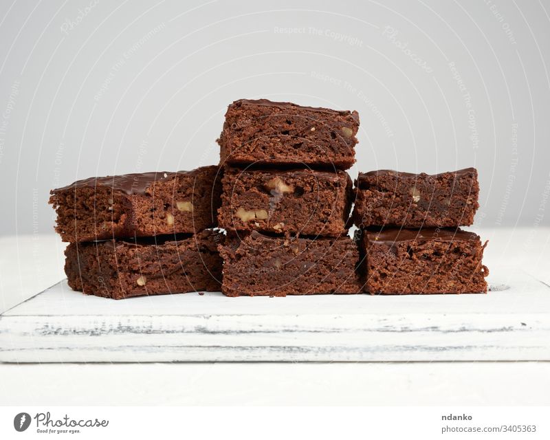 Stapel von quadratisch gebackenen Brownie-Schokoladenkuchenscheiben mit Walnüssen Bäckerei schwarz braun Kuchen Nahaufnahme Kakao Essen zubereiten Küche dunkel