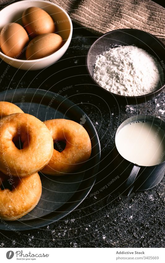 Doughnuts in der Nähe von Zutaten auf dem Tisch Bestandteil Koch Küche Rezept Mehl melken Ei Utensil Gebäck Lebensmittel Serviette Löffel geschmackvoll lecker