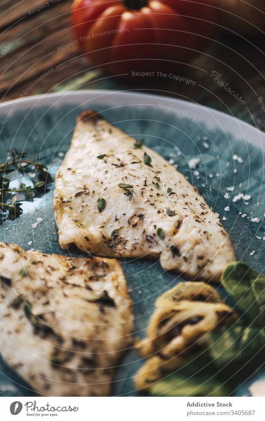 Gebratener Fisch mit Kräutern und Gemüse Kraut Speise Tisch Basilikum Filet Teller schäbig hölzern frisch Lebensmittel geschmackvoll Mahlzeit Tomate Zwiebel