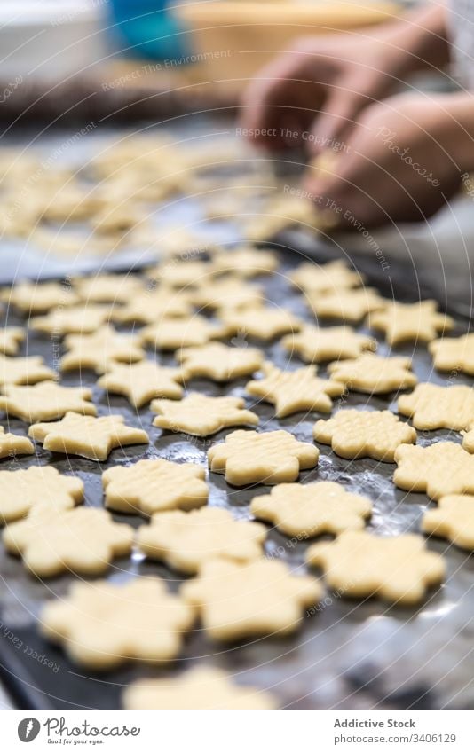 Getreidebäcker, der Kekse auf dem Tisch backt Bäcker geschnitten Bäckerei Teigwaren Mehl Koch Küchenchef Arbeit Kutter Werkzeug Lebensmittel Gebäck Bestandteil