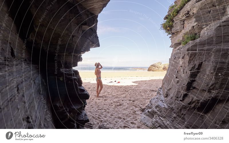 Junge Frau betrachtet eine Höhle aus Felsen in Galicien, Spanien Tourismus wandern Galicia Ribadeo Castros Illas atlantisch Bucht touristisch Kathedralen Klippe