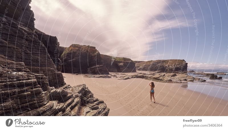 Junge Frau beim Strandspaziergang in Galicien Tourismus wandern Galicia Spanien Ribadeo Castros Illas Felsen atlantisch Bucht touristisch Kathedralen Klippe