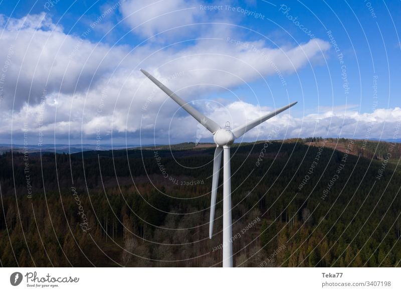 Windrad vor einer dunklen Waldhügellandschaft und Wolkenlandschaft Air hell Wolkenlandschaften dunkel Elektrizität Energie von oben Ökostrom Turbine Rad