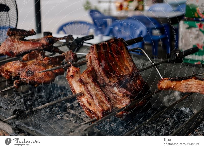 Fleisch am Spieß, das auf einem Grill brät Fleischkonsum grillen braten lecker heiß Glut Grillsaison Ernährung Grillrost Lebensmittel Grillkohle Sommer draußen