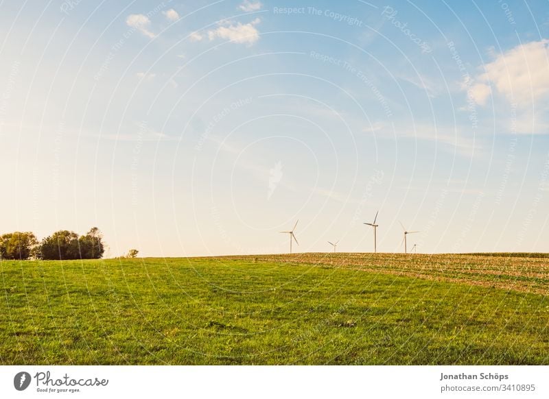 ökologisches Windkraftwerk mit erneuerbarer grüner Energie auf einem Feld in der Abendsonne alternativ Hintergrund blau Wandel & Veränderung Sauberkeit