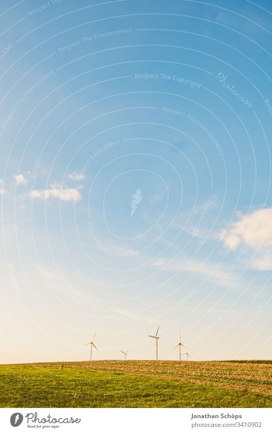 ökologisches Windkraftwerk mit erneuerbarer grüner Energie auf einem Feld in der Abendsonne alternativ Hintergrund blau Wandel & Veränderung Sauberkeit