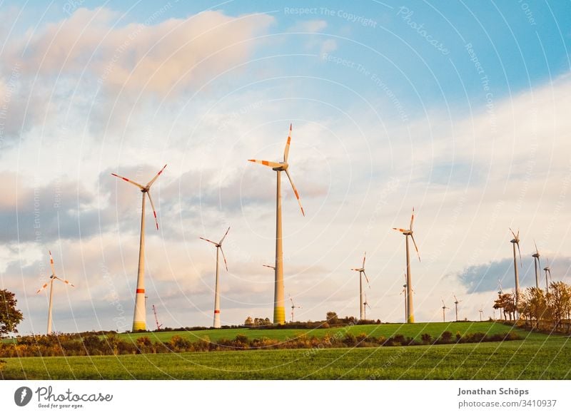 ökologisches Windkraftwerk mit erneuerbarer grüner Energie auf einem Feld in der Abendsonne alternativ Hintergrund blau Wandel & Veränderung Sauberkeit