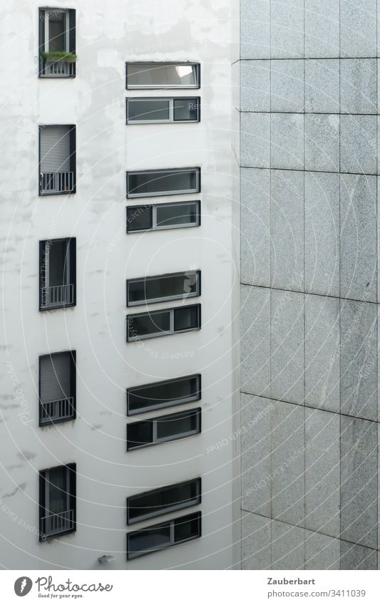 Fassade eines Hochhauses mit Fenstern im Hoch- und Querformat sowie Granitplatten in lichtem Grau Haus Architektur grau lichtgrau trist Fensterrahmen Quarantäne