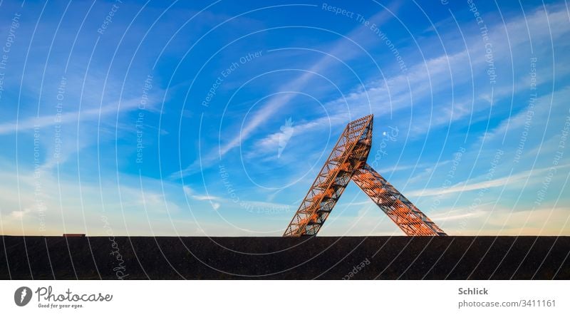 Saarland Saarpolygon auf der Halde Duhamel leuchtet im ersten Sonnenlicht rot Saaarpolygon Deutschland Morgen glühen Mond Blauer Himmel Wahrzeichen Berhalde