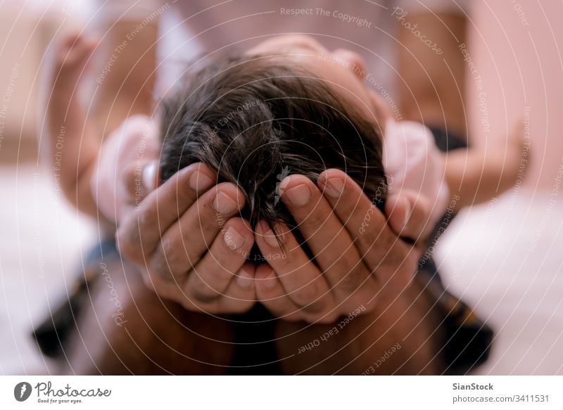 Der Vater hält den Kopf seines Neugeborenen in den Händen, ganz nah. Baby Beteiligung neugeboren niedlich Hand Kind Kaukasier Pflege Kindheit Unschuld schön