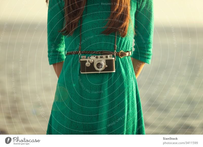 Vintage-Foto, brünettes Mädchen mit Retro-Kamera Strand Fotokamera altehrwürdig retro Meer Urlaub Menschen Sommer reisen blau Fotograf Mode Lifestyle Feiertag