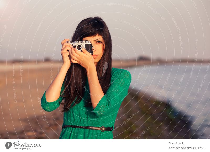 Vintage-Foto, brünettes Mädchen mit Retro-Kamera Strand Fotokamera altehrwürdig retro Meer Urlaub Menschen Sommer reisen blau Fotograf Mode Lifestyle Feiertag