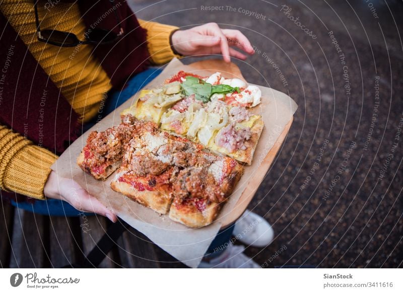 Draufsicht auf eine Frau, die mit der Hand Pizza holt Lebensmittel Italienisch Käse Tomate Straße Mozzarella Mahlzeit Nahaufnahme Hände Halt halten Top Ansicht