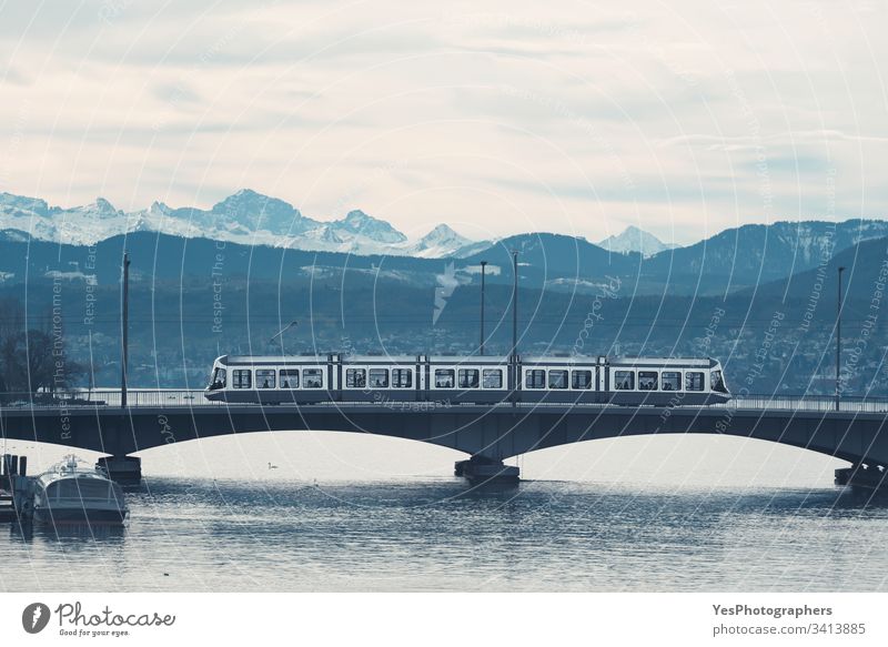 Tram in Zürich auf der Brücke über den See. Skyline der Berge Schweiz Blaue Stunde Stadtrundfahrt Duoton Europa Europäer Landschaft Monochrom Morgen Bergkette