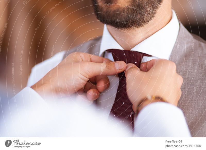 Nahaufnahme von zwei Händen, die einem Bräutigam bei seiner Hochzeit mit der Krawatte helfen Anzug Person männlich Dekoration & Verzierung Tag Weste striegeln