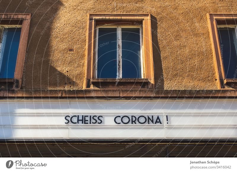 Scheiß Corona! Ärger über den Coronavirus auf einer Anzeigetafel an einer Fassade Menschenleer Risiko Panik corona hysterie scheiße Kraftausdruck Fluchen Haus