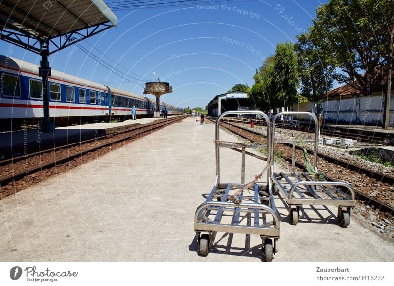 Bahnsteig, Gepäckwagen und Zug nebst Wasserturm im Bahnhof von Phan Thiet, Vietnam Eisenbahn Schönes Wetter Himmel blau Verkehr Gleise Ferien & Urlaub & Reisen