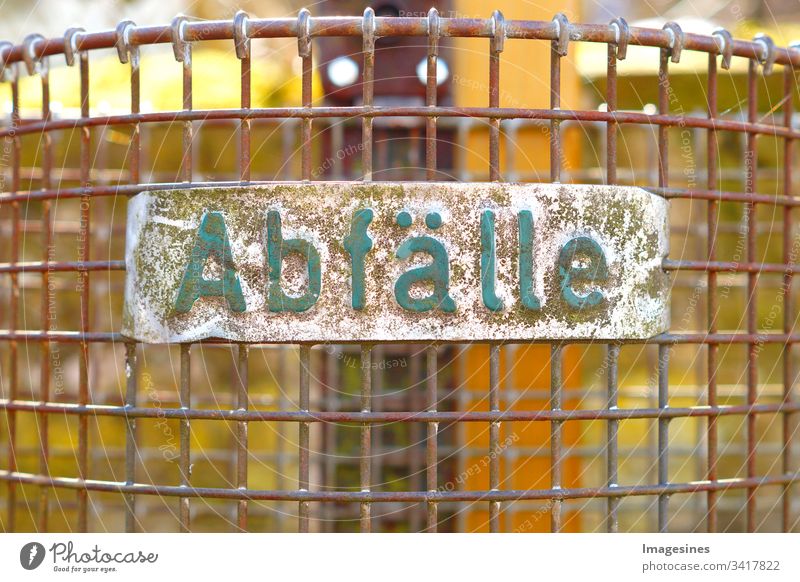 Abfälle - Abfall Müllkorb. Nahaufnahme Abfallkorb Drahtkorb mit einem Schild, Text - Abfälle. Umweltthema Hintergrund mit Mülleimer, Papierkorb. Umwelt schützen, Müll wegwerfen.