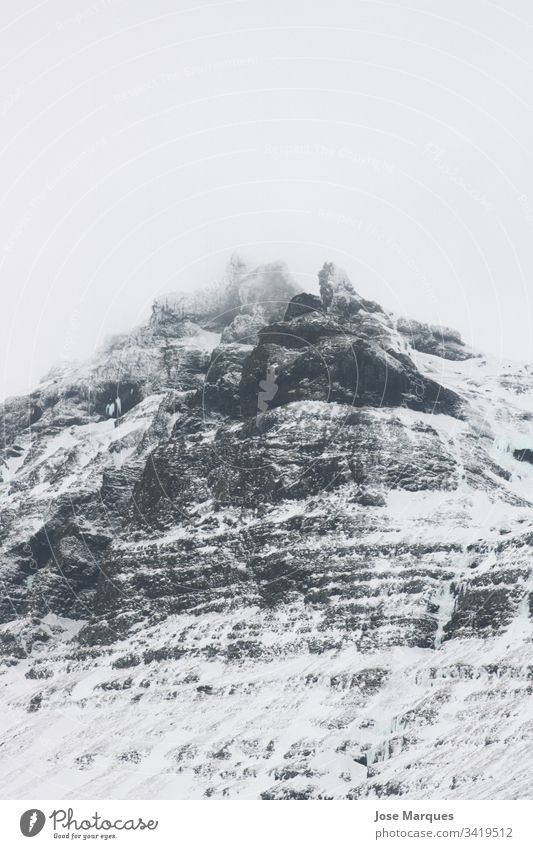 Schneeberg zwischen den Wolken Berge u. Gebirge schneebedeckter Berg Landschaft Schneelandschaft kalt Island Norden Nebel Natur vijes Tourismus Winter