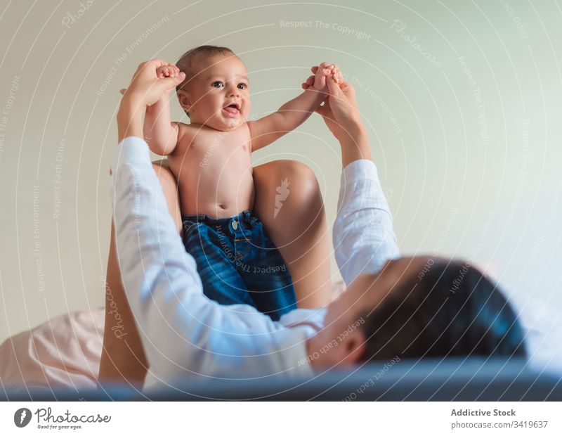 Glückliche gesichtslose Mutter spielt mit Baby im Schlafzimmer spielen Lächeln Lügen genießen Zusammensein Kind Eltern bezaubernd Liebe wenig Pflege unschuldig