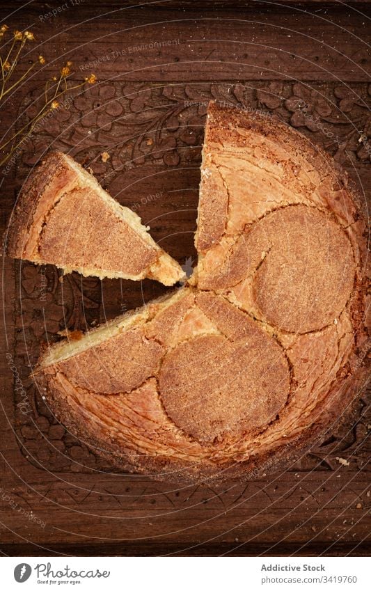 Torte mit abgeschnittenem Stück auf Holztisch Pasteten Tisch Spielfigur frisch Lebensmittel Ornament hölzern Blume lecker geschmackvoll Brot natürlich organisch