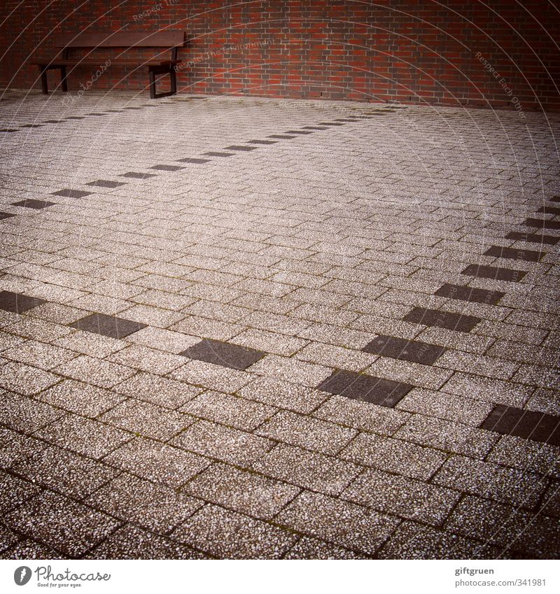 eingeparkt Mauer Wand sitzen Bank Sitzgelegenheit Parkplatz Backstein Steinboden Linie Strukturen & Formen Einsamkeit leer grau skurril parken Perspektive trist