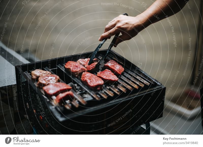 rohes Fleisch auf einem Grillrost Barbecue Barbecue-Grill Grillen grillen Rindfleisch Blut Essen zubereiten Abendessen Lebensmittel Raster gegrillt erwärmen