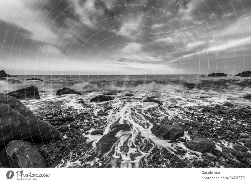 Wellen brechen und spülen die Kiesel am Strand, Wolken ziehen vorbei, der Blick wandert zum Horizont Kieselsteine Brandung Meer nass Steine Himmel Natur Küste