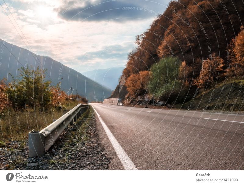 Bergstraße und Himmel mit Sonnenstrahlen in Georgien Kaukasus Sakartwell Asphalt Herbst Wolken Tag Menschenleer Hügel Landschaft Licht Berge u. Gebirge Natur