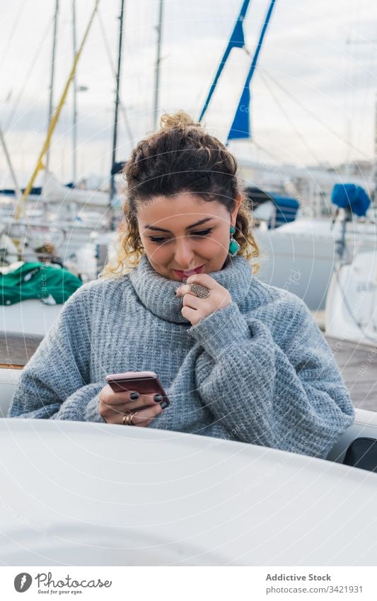 Zufriedene Dame mit Smartphone auf Yacht Frau benutzend Jacht Lächeln Browsen Handy Lachen zufrieden Inhalt genießen Surfen zuschauen Anschluss Gerät Apparatur