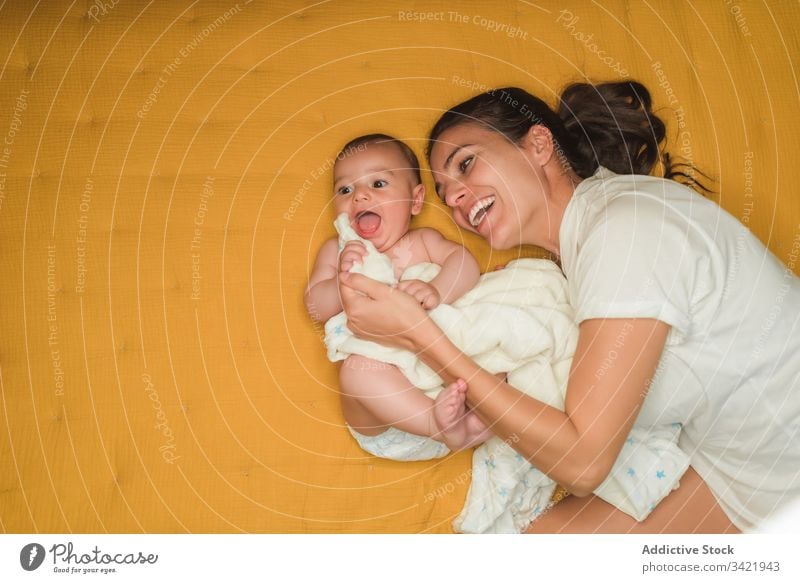 Überglückliche Mutter liegt mit Baby Lügen Lachen Lächeln Zusammensein genießen Kind bezaubernd wenig unschuldig niedlich Glück Liebe Eltern Zuneigung ruhen