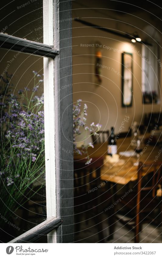 Rustikales Restaurant mit Holztisch und Blumen Café Fenster Tisch Wein rustikal hölzern ländlich Innenbereich Design altehrwürdig gemütlich Dekor retro