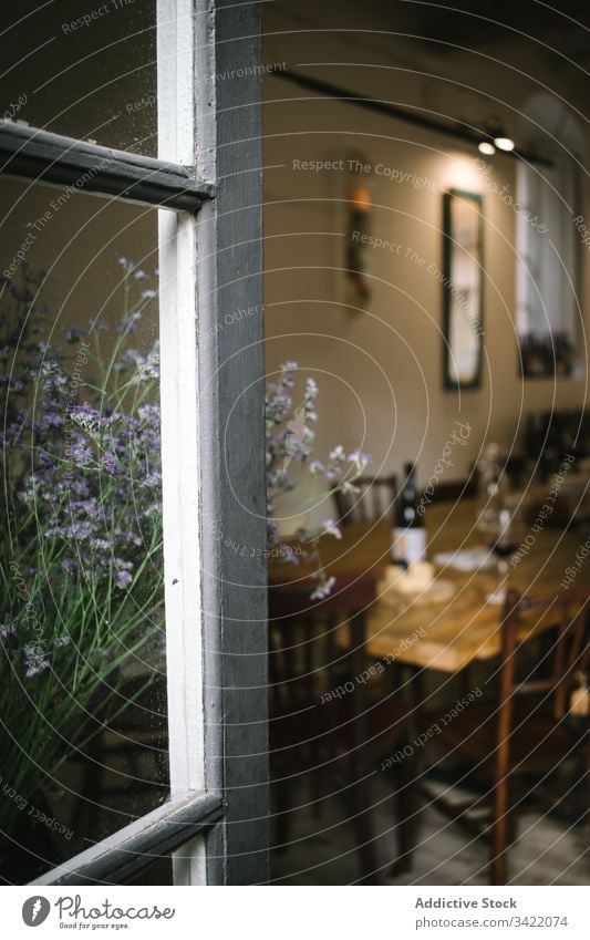 Rustikales Restaurant mit Holztisch und Blumen Café Fenster Tisch Wein rustikal hölzern ländlich Innenbereich Design altehrwürdig gemütlich Dekor retro