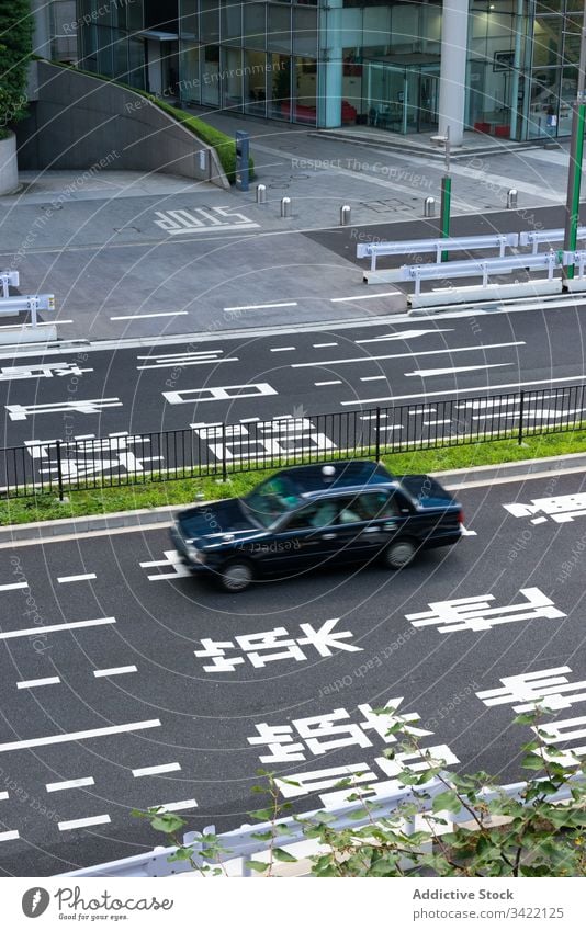 Auto fährt auf der Straße in der Stadt PKW Großstadt Markierung urban Asphalt modern Verkehr Fahrzeug Hieroglyphen reisen Tourismus Japan Asien schwarz Revier