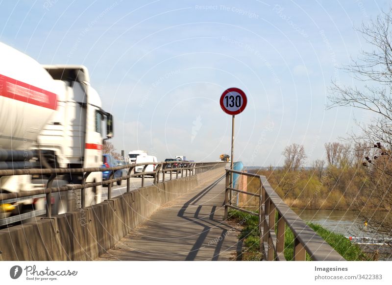 130 Autobahn Schild - Verkehrsschild im Straßenverkehr. Geschwindigkeitsbegrenzung, deutsche Autobahn km / h. Autobahn in Deutschland mit Fahrzeugen - Autos und Lastwagen - Lkws, blauer Himmel Hintergrund. Verkehrssicherheit, Konzept