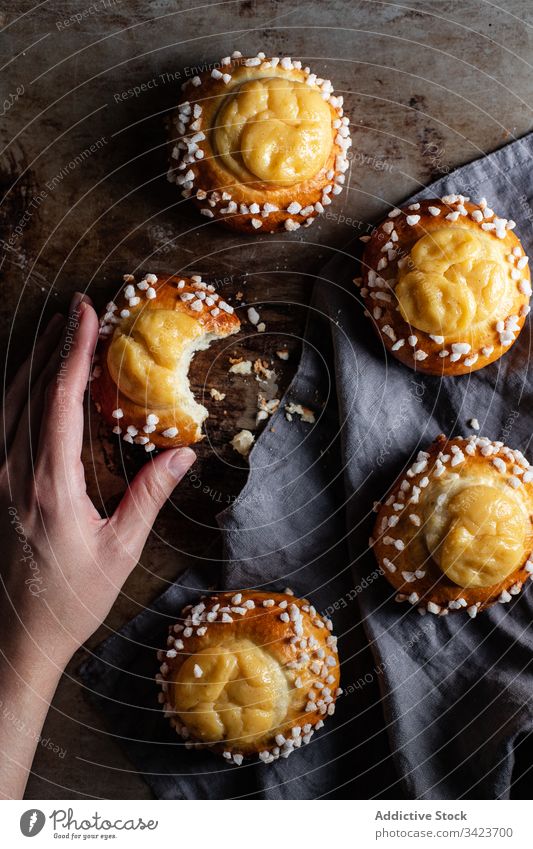 Frau isst süße hausgemachte Brötchen Gebäck Lebensmittel backen essen Hand Biss selbstgemacht geschmackvoll lecker frisch Sahne Ernährung appetitlich Koch