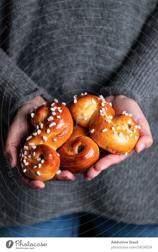 Frau hält köstliche hausgemachte Brötchen Lebensmittel backen selbstgemacht Hand geschmackvoll Gebäck süß Safran Tradition lecker frisch Ernährung appetitlich