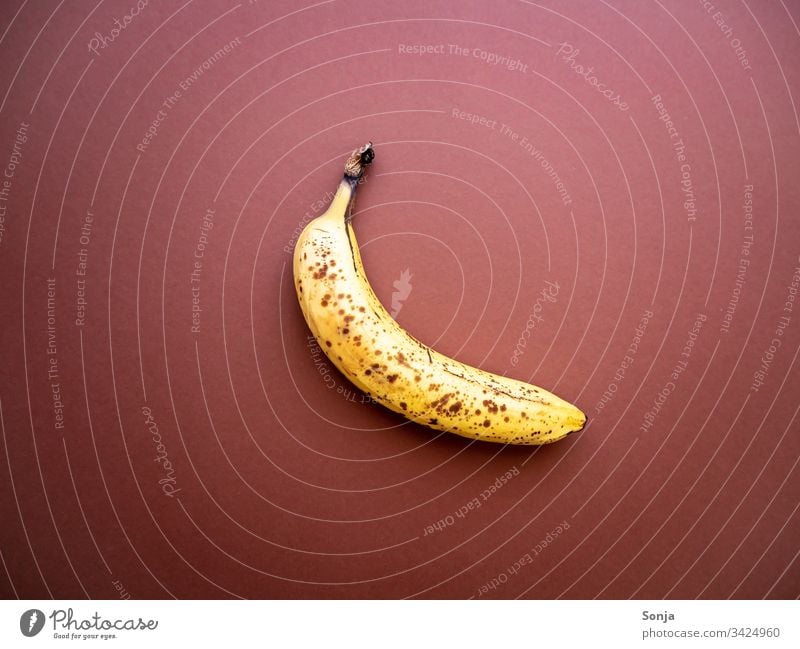 Überreife Banane mit Punkten auf einem braunen Hintergrund überreif punkte hintergrund draufsicht noch gut wegwerfen Lebensmittel Detailaufnahme Bioprodukte