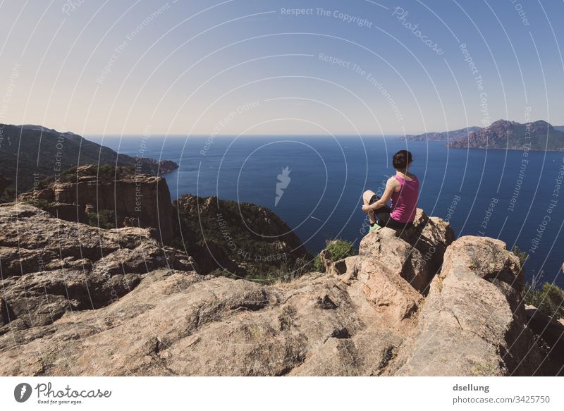 eine Frau genießt nach einem Wandertrip die erreichte Aussicht auf Meer und Felsen in der Sonne Sonnenstrahlen entfernung Blick schön Wellness entdecken hell