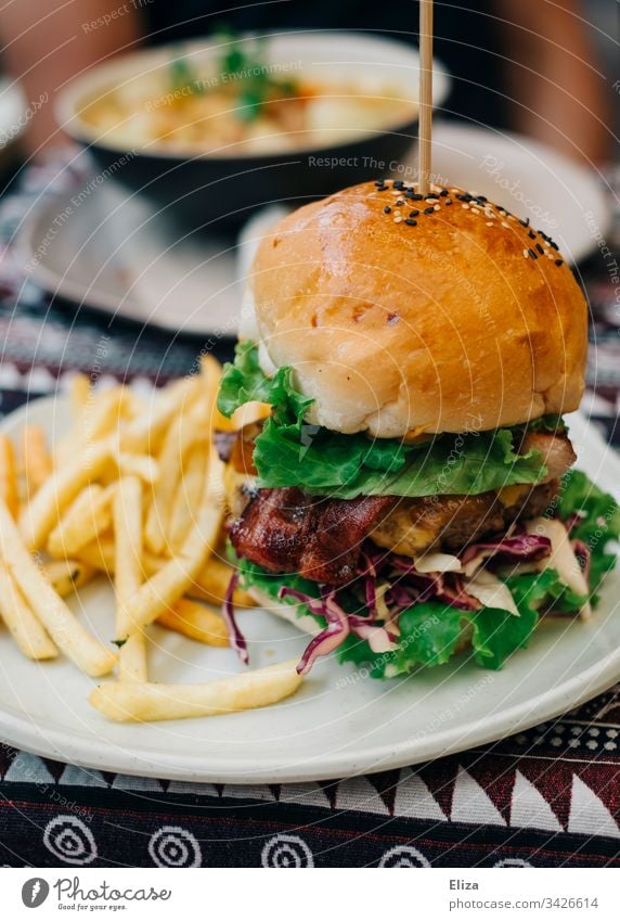 Ein leckerer Burger mit Pommes auf einem Teller; Fastfood Hamburger Fast Food Restaurant frich Mittagessen Mahlzeit Essen frisch Lebensmittel ungesund Fleisch