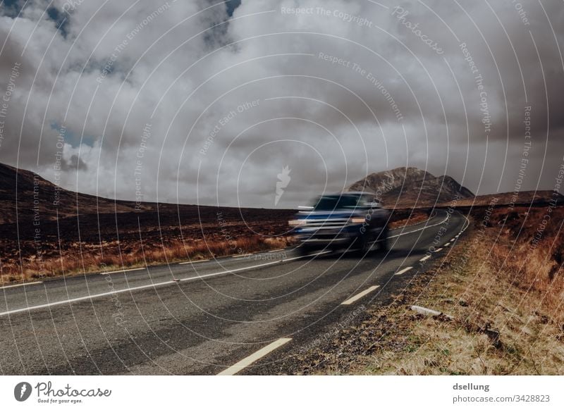 Straße, die von einem Berg wegführt, mit fahrendem Auto im Vordergrund Ziel Richtung Wohlgefühl stille ruhig Dämmerung Schönes Wetter Umwelt Schatten Licht