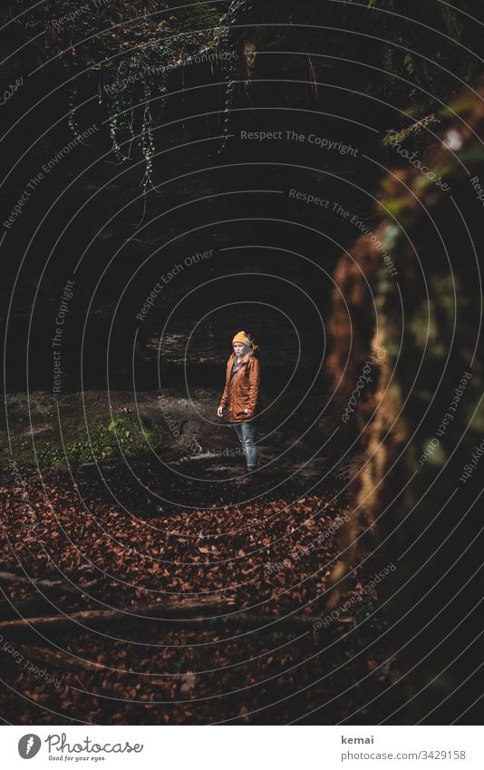 Frau in einer Schlucht im Wald, schaut in Kamera mystisch Naturmystik geheimnisvoll Tag braun natürlich grün Stein Mensch schauen Laub düster dunkel stehen