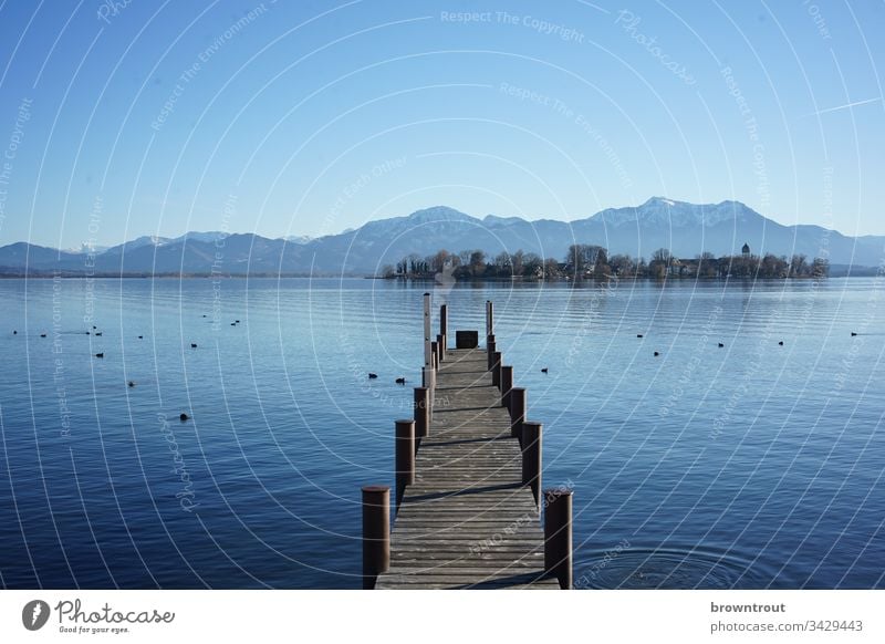 Bootssteg am Chiemsee mit Blick auf die Fraueninsel. Steg See Wasser Holz blau Alpen Insel Berge u. Gebirge Blauer Himmel Gstadt Außenaufnahme Natur Landschaft