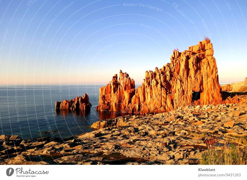 Roter Fels am Meer Roter Fels mit Durchblick zum Meer Felsen mit Fahrräder Strand Urlaub Abendstimmung blauer Himmer Meerblick Attraktion am Meer