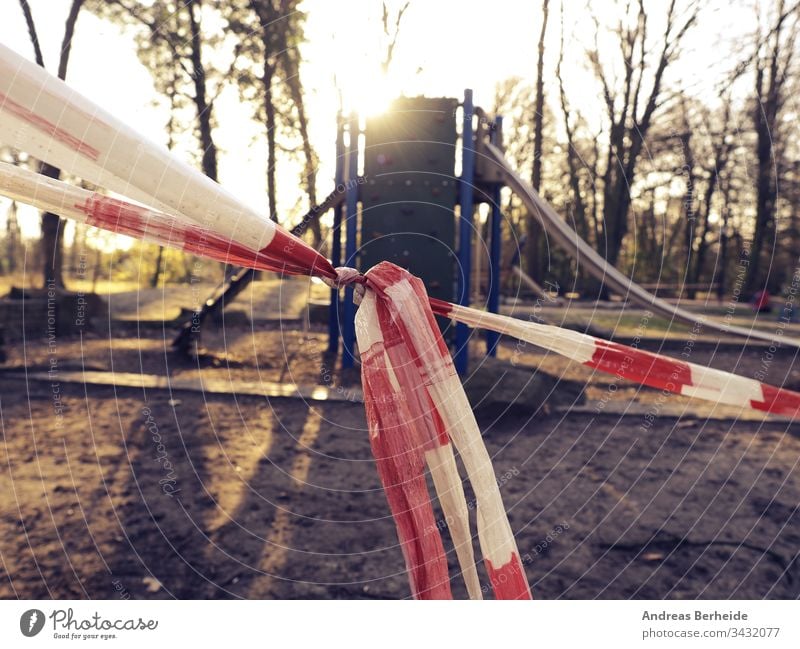 Nahaufnahme des Absperrbandes vor einem Spielplatz Korona Virus Schloss Ausfahrt leer zu Hause Aufenthalt Klebeband Barriere Park Kind Spaß Frühling Sommer