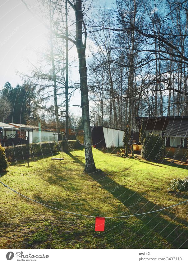 Roter Wimpel Feriensiedung Bungalows Sonnenlicht schönes Wetter Bäume Himmel Wolken Wiese leuchtende Farben Absperrung Kette rot Farbtupfer Signalfarbe Licht