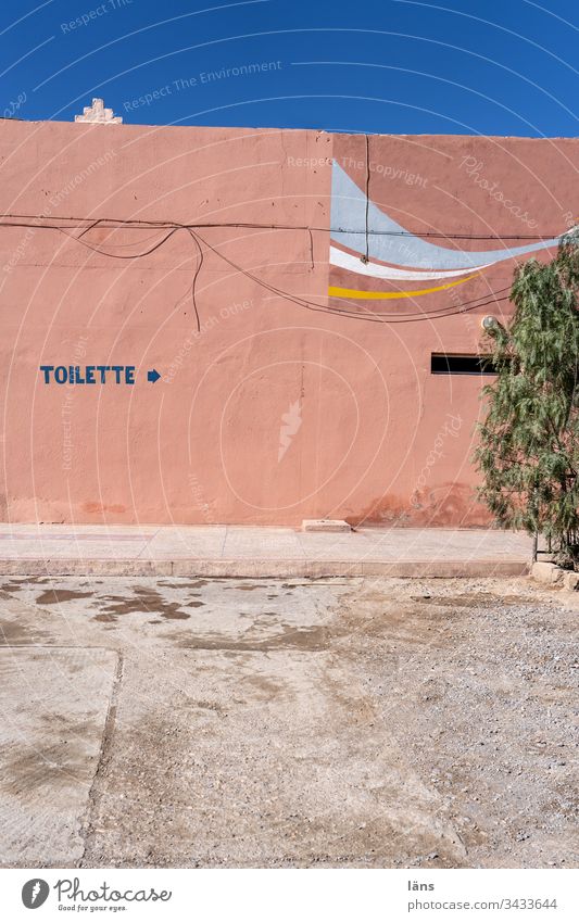 Toilette Wegweiser in Marokko Haus Fasseade Schrift Bedürfnis Pfeil Richtung Menschenleer Hinweis Orientierung Empfehlung Navigation rechts Wege & Pfade